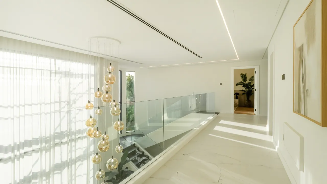 Jumeirah Islands home renovation upper landing with glass railing and chandelier Upgraded house upper landing with glass railing and chandelier